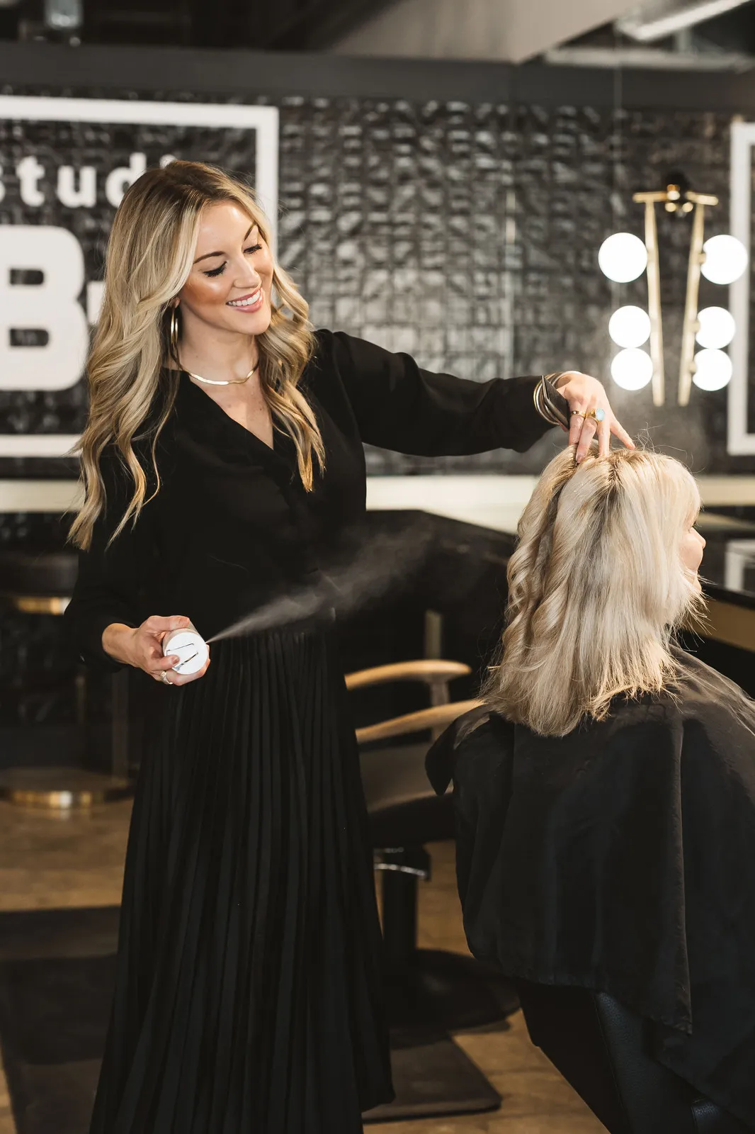 A Studio B-3 stylist finishing a blonde balayage at the styling chair in Chattanooga